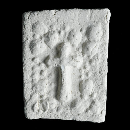 Sacred clay tablet with floral arch enclosing cross in center