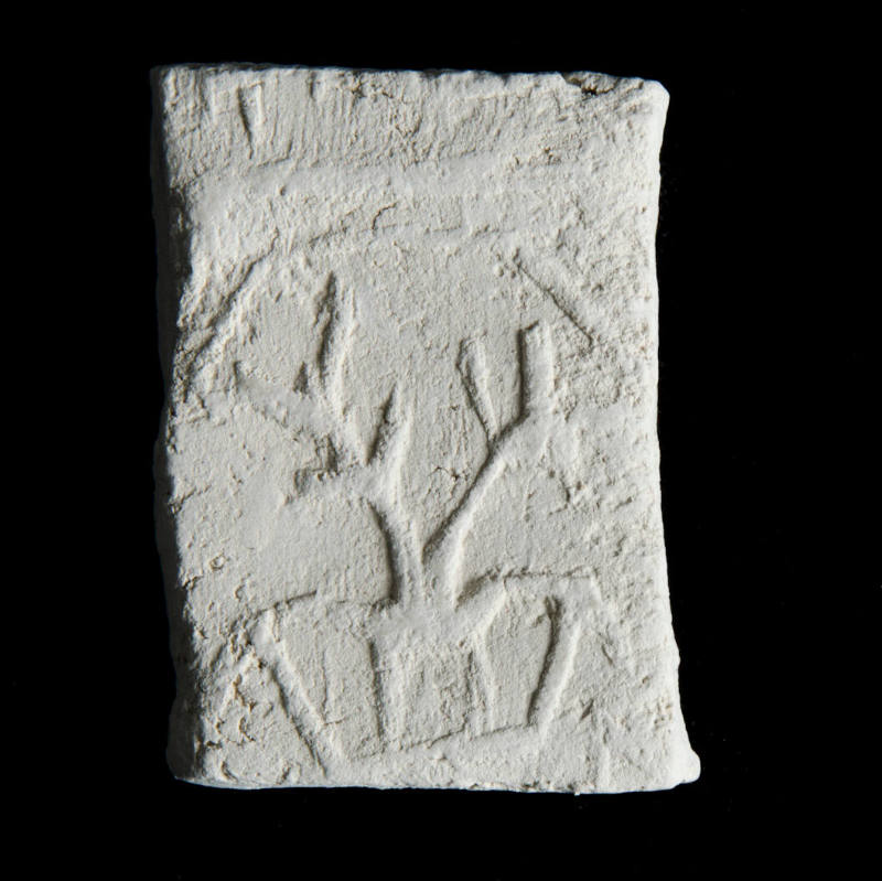 Sacred clay tablet with design perhaps representing a pair of plants in a container