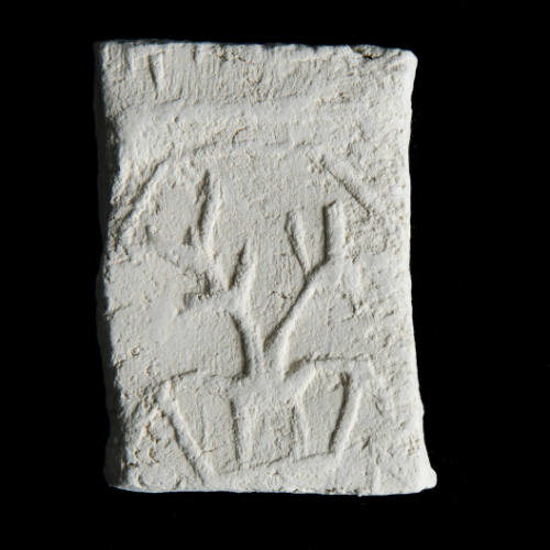 Sacred clay tablet with design perhaps representing a pair of plants in a container