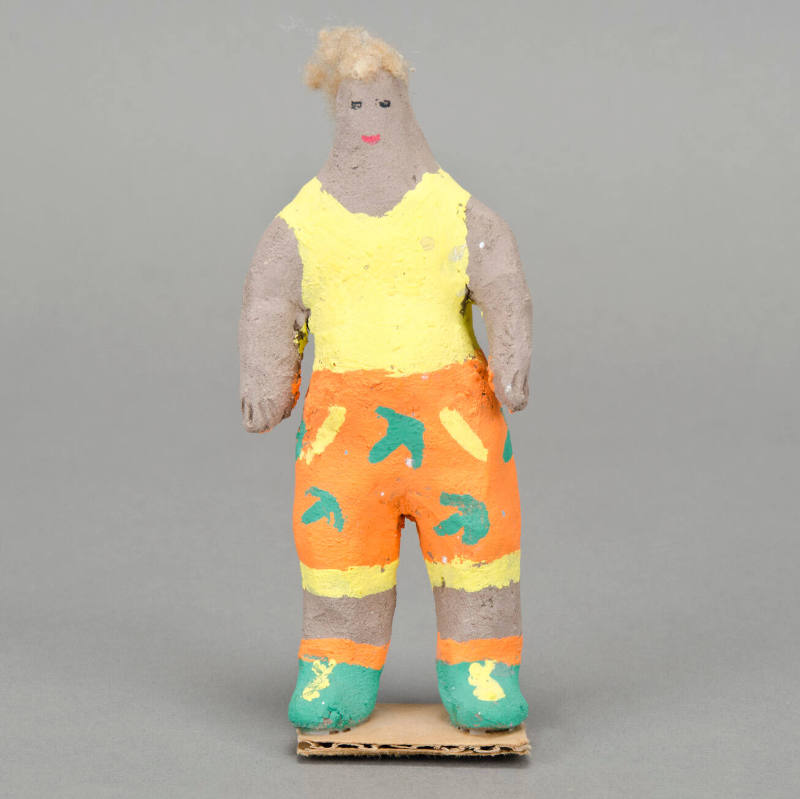 Man in orange print shorts figurine