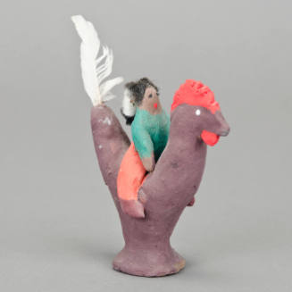 Man riding chicken figurine