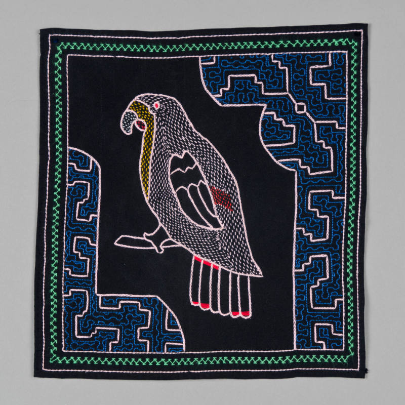 Embroidered textile with pink parrot