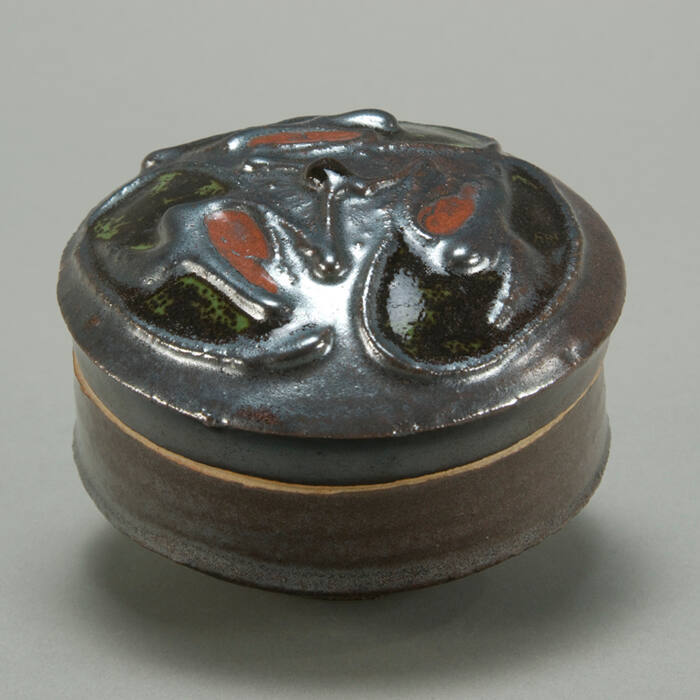 Small round box with raised design on lid