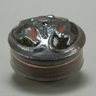 Small round box with raised design on lid