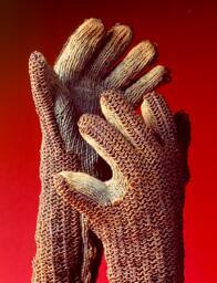 Pair of gloves that have chain mail on the outside, which is sewn onto a cotton knit glove.  Th…