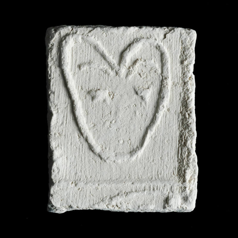 Sacred clay tablet with representation of a heart-shaped animal head or mask